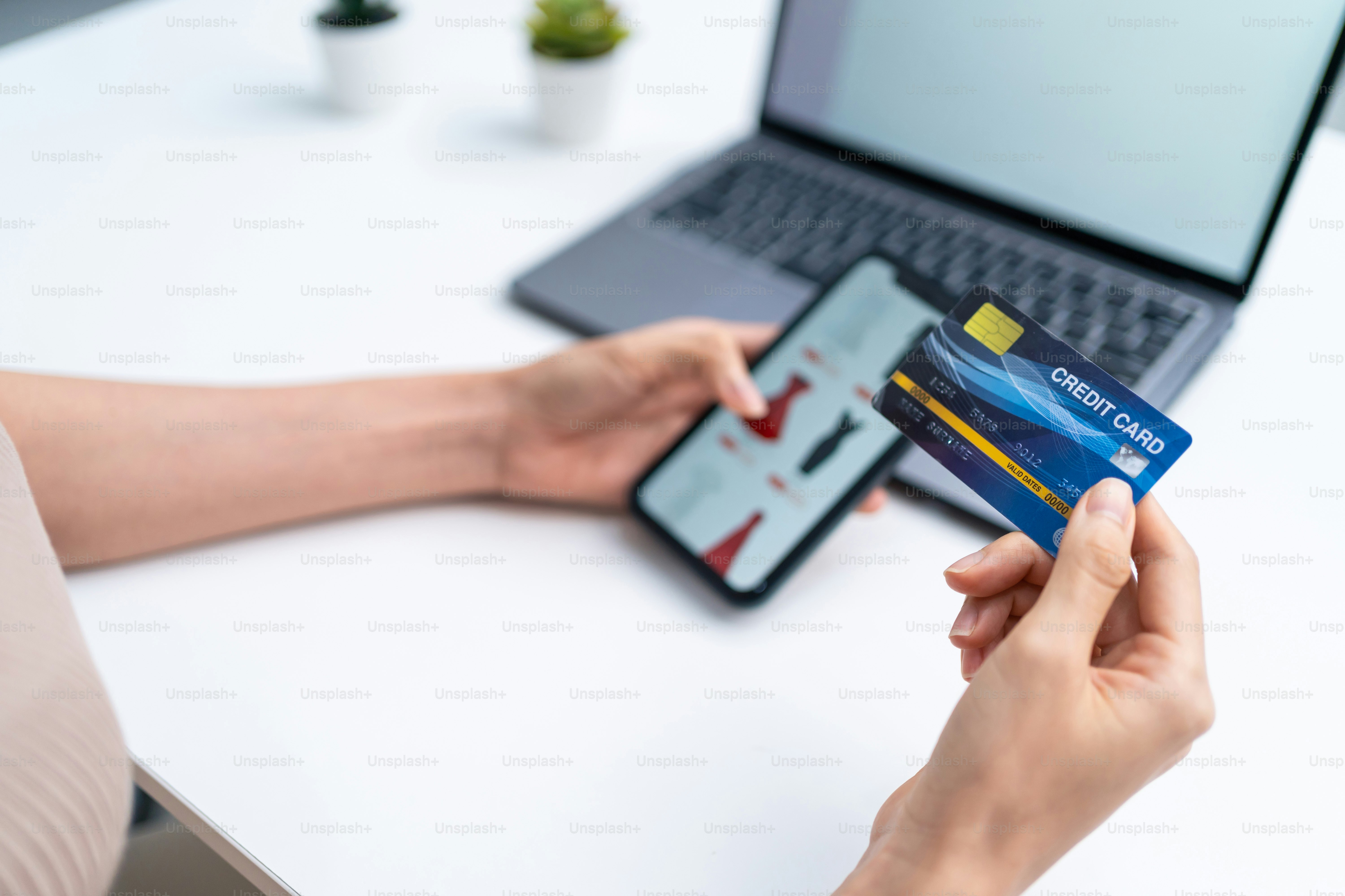 Wanita muda Asia yang menggunakan ponsel untuk berbelanja online di rumah. Gadis cantik yang menarik memegang kartu kredit di tangan membeli dan membeli produk di situs web di smartphone. Konsep e-commerce.