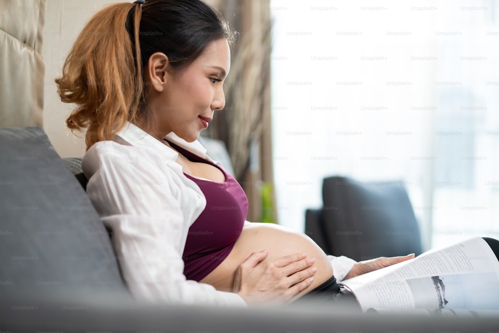 Smiling Pregnant Woman Putting Headphones On Her Belly In The Living Room  Stock Photo, Picture and Royalty Free Image. Image 44806928.