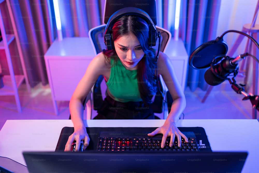 La bella giocatrice asiatica di Esport gioca al videogioco online sul computer. Attraente giovane ragazza che gioca a un giocatore perdente che si sente frustrato e arrabbiato durante la trasmissione in diretta streaming giocando a un torneo cibernetico.