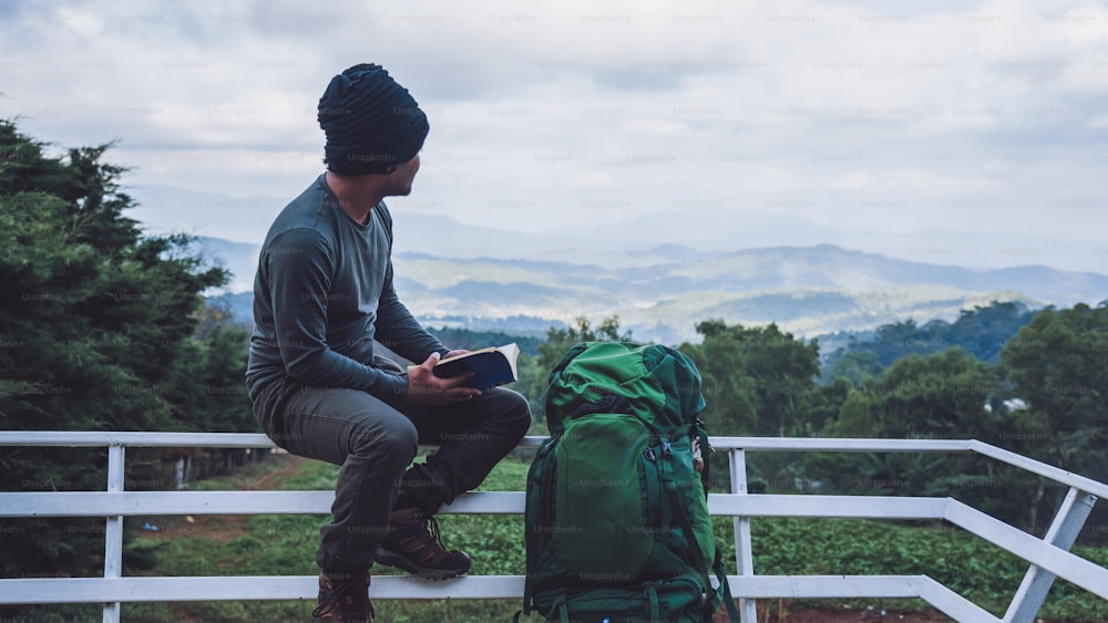 남자 여행자는 북쪽의 신선한 공기, 태국의 치앙마이에서 산에서 책을 읽고 자연을 여행하고 있습니다.