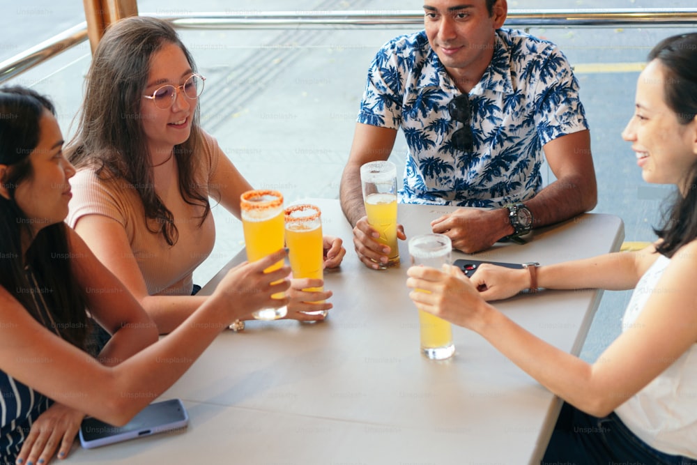 Eine Gruppe lächelnder junger Leute, die sich in einer Bar teilen.