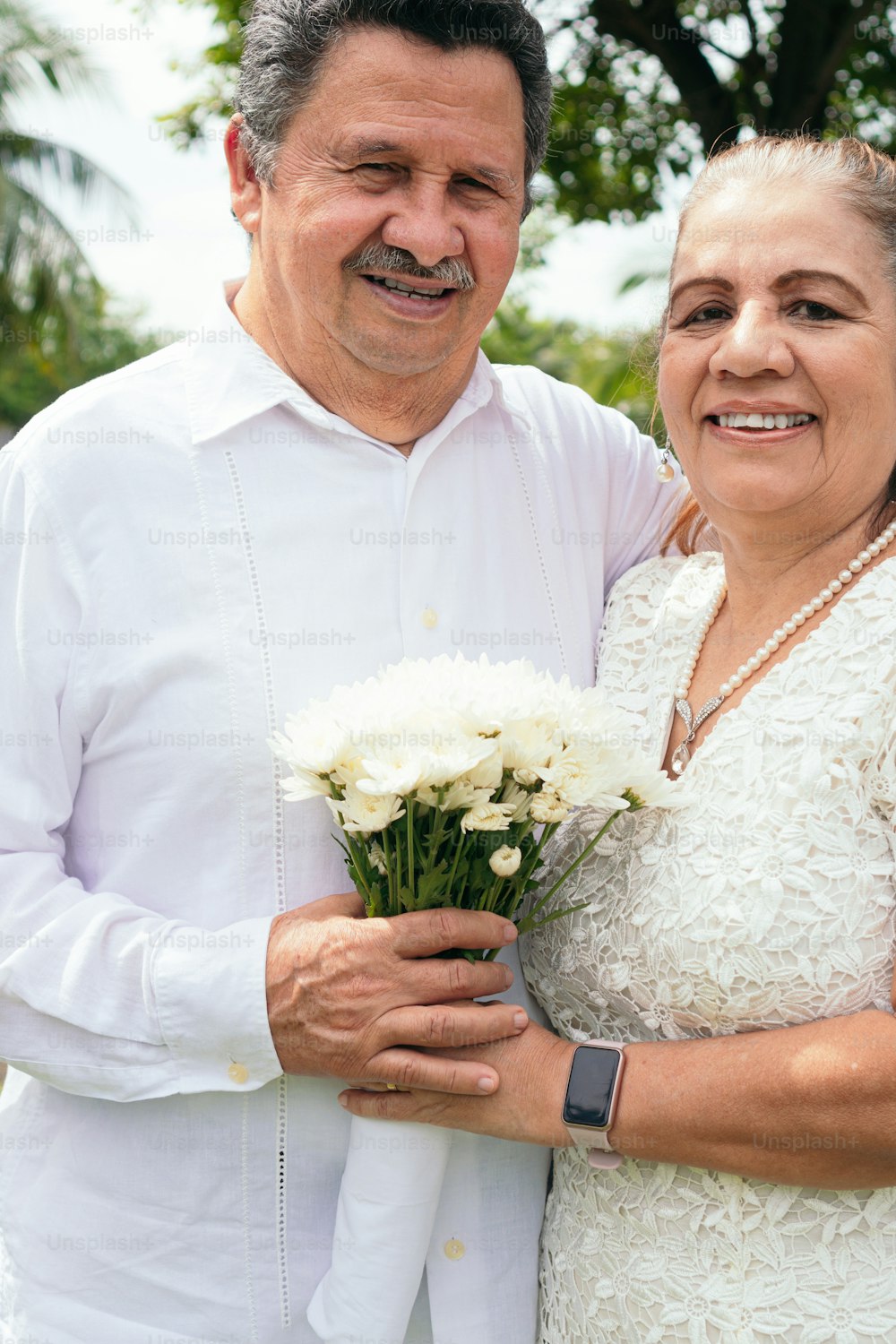 Hispanic newlywed couple embracing on their wedding day