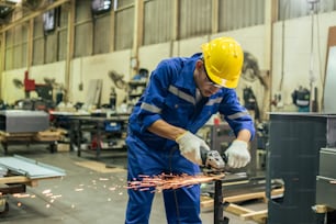 Asian attractive man industrial worker working in manufacturing plant. Young handsome male industry factory engineer wear helmet and processes order and product at manufactory warehouse with happiness
