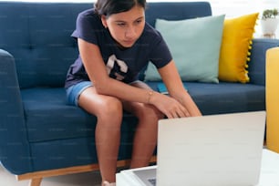 Teen Girl Working On Laptop In living room