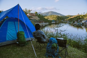Asian man travel nature. Travel relax, Camping in a rural village on the mountain, near the lake.