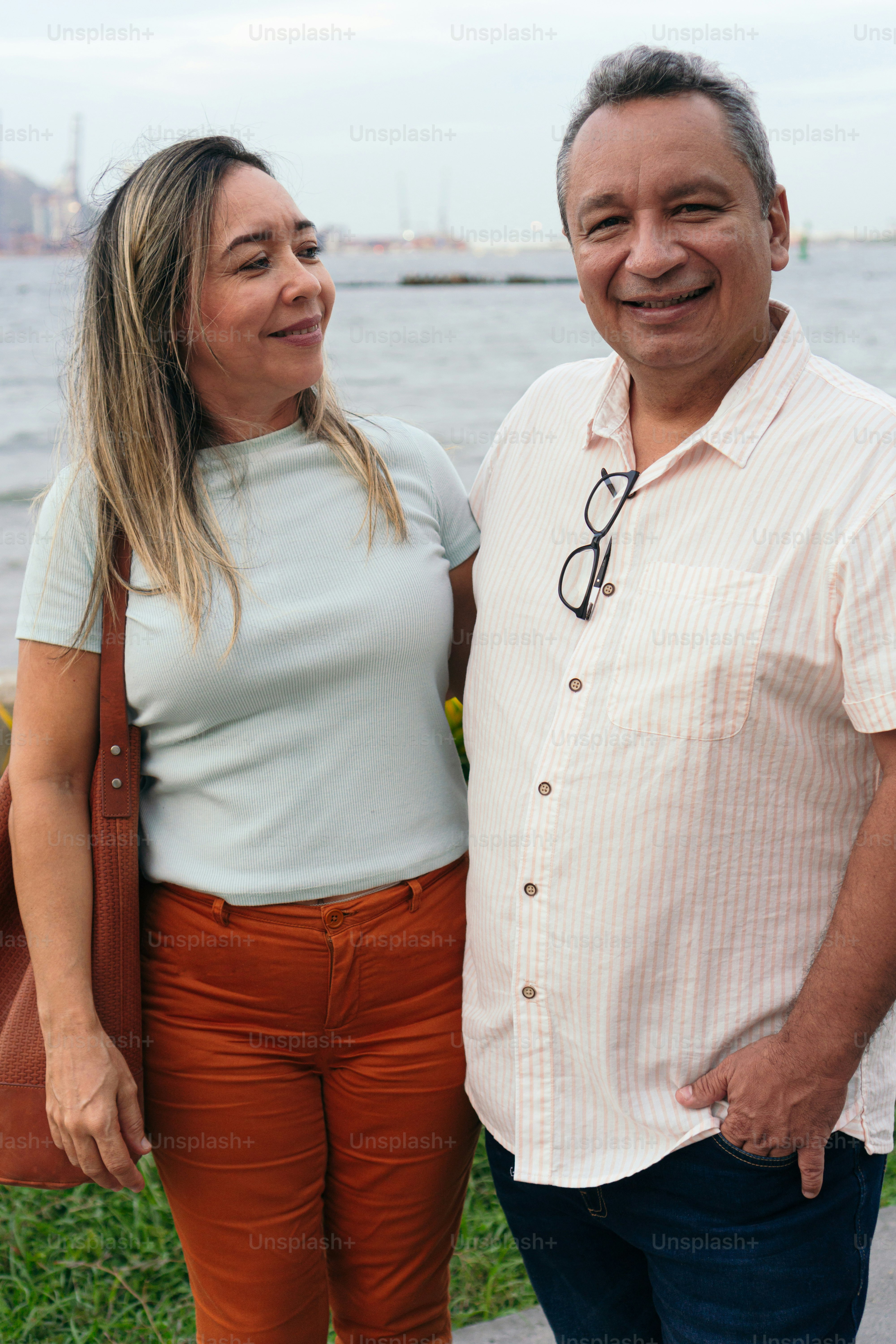 50-year-old couple smiling happily and hugging standing in park