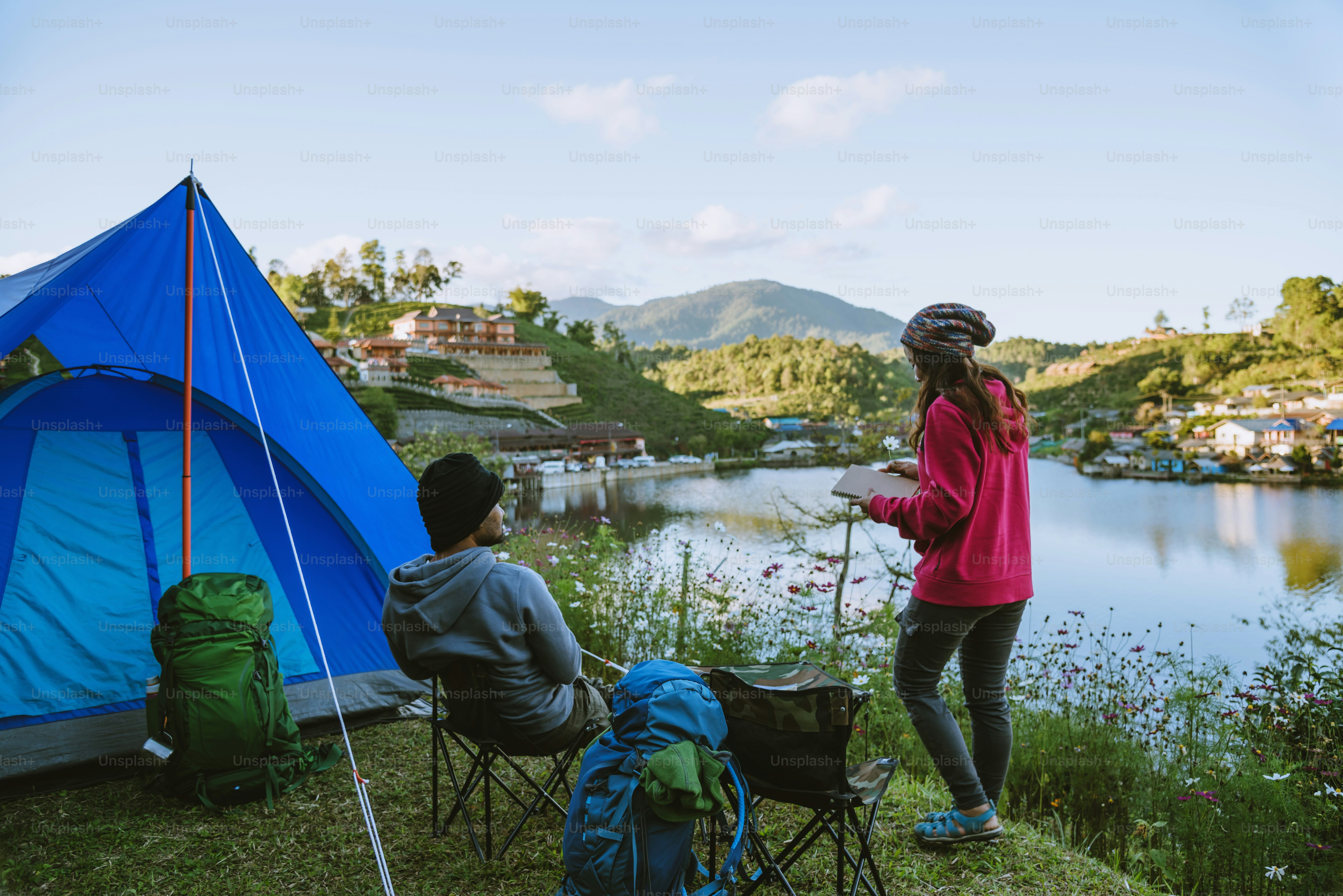 Couple Enjoying Camping Holiday In Countryside.Camp in the mountains near of the lake.