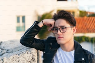 Un jeune homme avec des lunettes regardant sur le côté