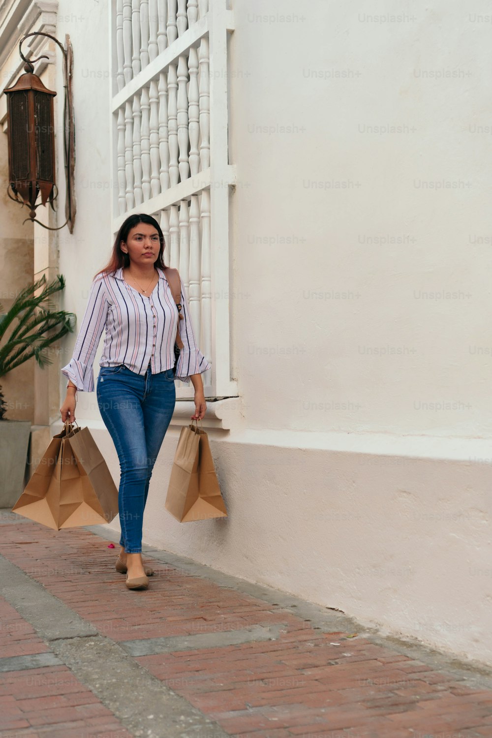 Latin Woman trägt eine Tasche bei einem Spaziergang durch die Stadt
