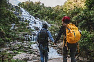 Reisen Sie entspannt, um die Wasserfälle von Paaren zu besuchen. Im Winter. Am Wasserfall Mae Ya Chiangmai in Thailand. Reisen Sie in die Natur. Sommer