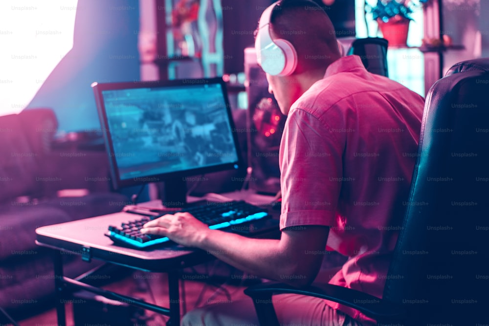 Hombre trasero del hombre del jugador jugando en una computadora.