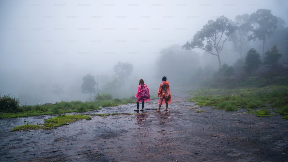 couples tourist with rain coat walking travel adventure nature in the rain forest. travel nature, Travel relax, Travel Thailand, rainy season, Happy, romantic.