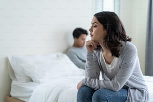 Asian young girl feel angry boyfriend having conflict domestic problem. New marriage man and woman feel heartbroken for quarrel conflict while sit on bed in bedroom. Family problem-separation concept.