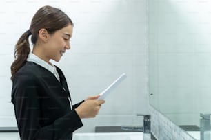 Asian applicant prepare for job interview in front of mirror at home. Attractive beautiful female feel nervous and excited while waiting for apply job with hr manager and practice speak with resume.