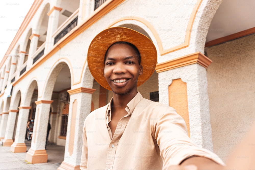 Joven feliz millennial tomando una selfie sonriendo a la cámara cerca de la ciudad colonial de honduras.