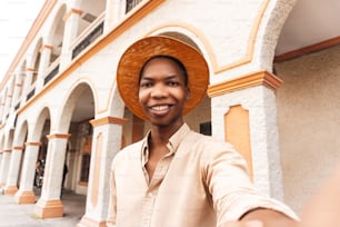 Jovem millennial feliz tirando uma selfie sorrindo para a câmera perto da cidade colonial de Honduras.