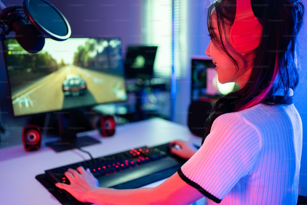 Asiatische schöne Esport-Spielerin spielen Online-Videospiel auf dem Computer. Attraktive junge Gaming-Spielerin fühlt sich glücklich und genießt Technologieübertragung Live-Streaming, während sie Cyber-Turnier zu Hause spielt
