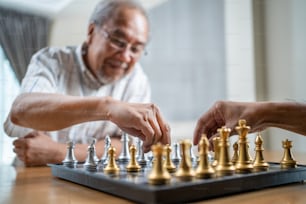 아시아 노인 노인은 여가 시간을 보내고 은퇴 후 집에 머물러 있습니다. 행복한 미소를 짓는 노인은 집에서 친구와 함께 체스 게임을 하는 활동을 즐긴다. 병원 의료 및 의료 개념
