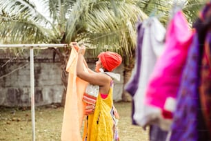 Mujer negra colgando ropa lavada.