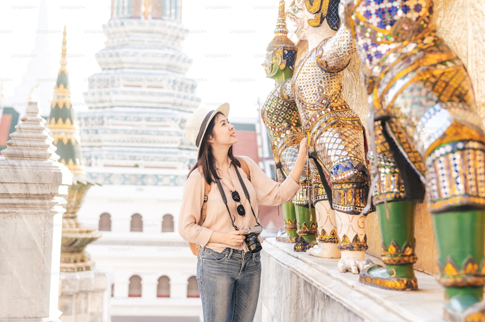 La donna asiatica turista gode di visite turistiche durante il viaggio nel tempio del buddha di smeraldo, Wat Phra Kaew, luogo turistico popolare a Bangkok, Thailandia