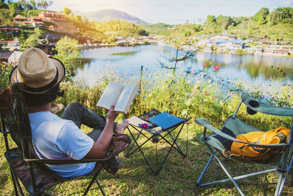 아시아 남자 관광객 캠핑과 작업 노트, 그녀는 행복하고 편안하며 책을 읽고, 자연을 여행하고, 여행을 즐깁니다.