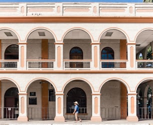 Tourist man with blue shirt and hat walking in front of the municipality of La Ceiba, Atlantida, Honduras.