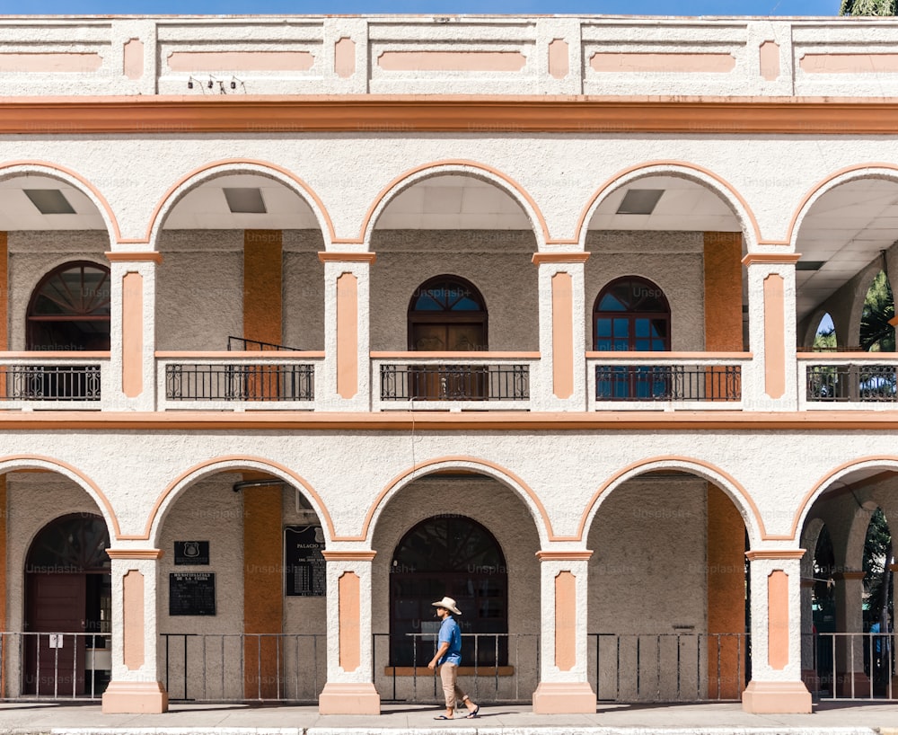 Tourist man with blue shirt and hat walking in front of the municipality of La Ceiba, Atlantida, Honduras.