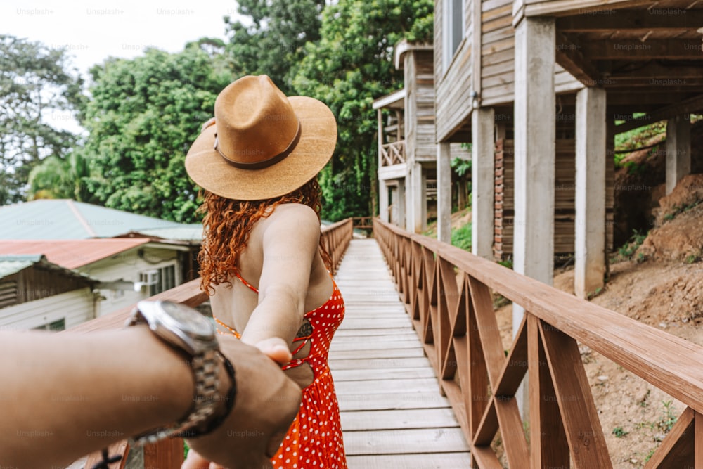 木製の橋の上を散歩するカップルのPOV、旅行と森の生活のコンセプト。