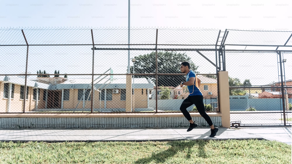 Hispanic young male running while training outdoors.