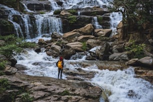旅行はアジアの女性の滝を訪れるためにリラックスしてください。冬に。滝メー屋チェンマイで。自然を旅する。夏