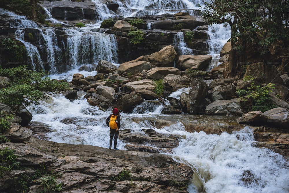 Reisen Sie entspannt, um die Wasserfälle der asiatischen Frau zu besuchen. Im Winter. Am Wasserfall Mae Ya Chiangmai. Reisen Sie in die Natur. Sommer
