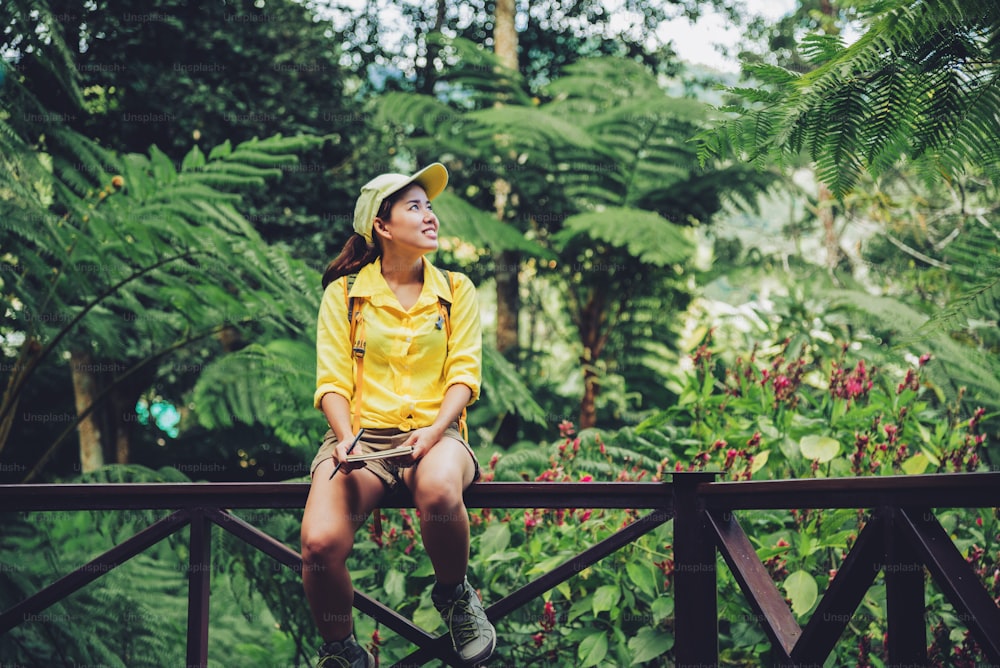 La joven que está sentada escribiendo, registrando y estudiando la naturaleza del bosque.