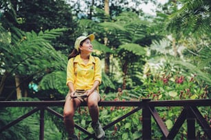 The young woman who is sitting writing, recording and studying the nature of the forest.