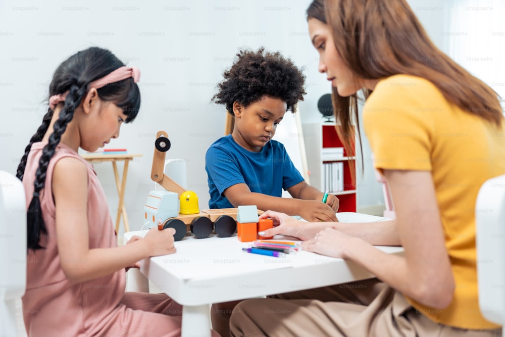 Asian beautiful young woman teacher teaching a lesson to kid at school. Attractive women instructor master explain and educate children student with fun activity in classroom at preschool kindergarten