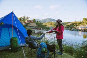 Couple Enjoying Camping Holiday In Countryside.Camp in the mountains near of the lake.