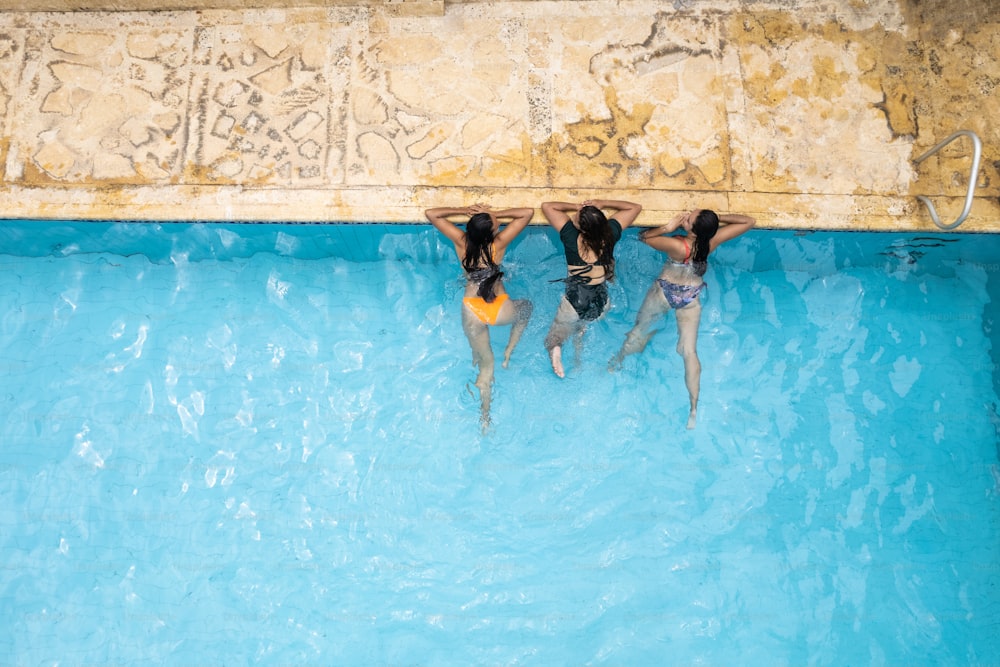 Vista aérea de mujeres descansando junto a la piscina.