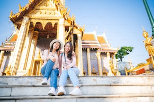 Touristen asiatische Frauen Freunde genießen Sightseeing während der Reise im Tempel des Smaragdbuddhas, Wat Phra Kaew, beliebter Touristenort in Bangkok, Thailand