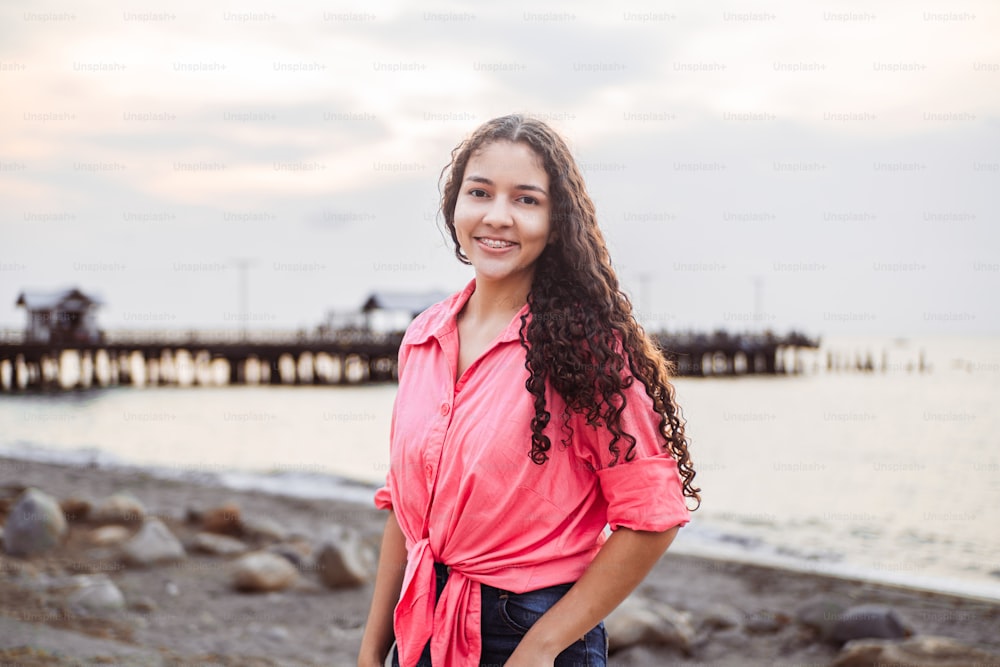 Retrato de uma mulher latino-americana sorridente e feliz vestindo uma blusa rosa
