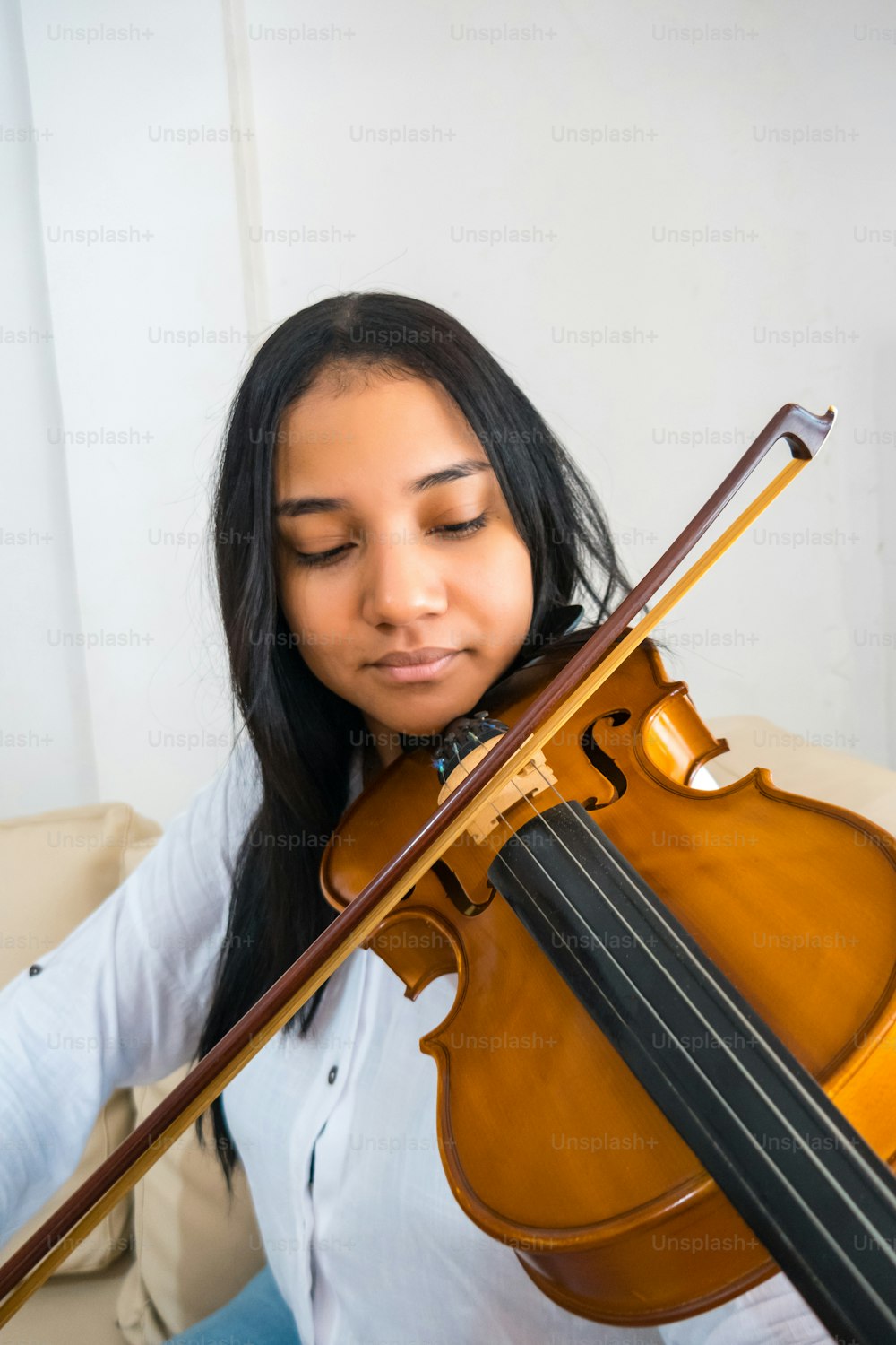 A pretty young teenager playing the violin; close-up