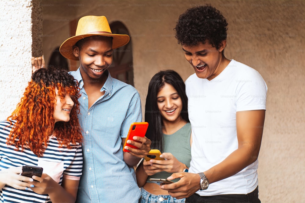 Groupe d’amis utilisant le téléphone portable, la technologie et le concept d’amitié.