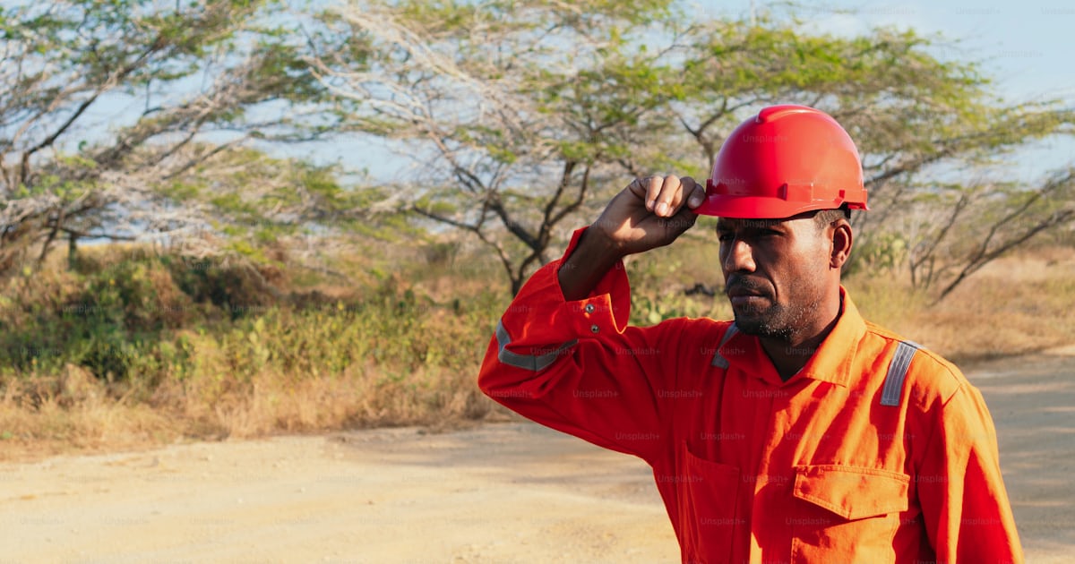 Homem mecânico africano colocando seu capacete. Conceito de engenheiro ...