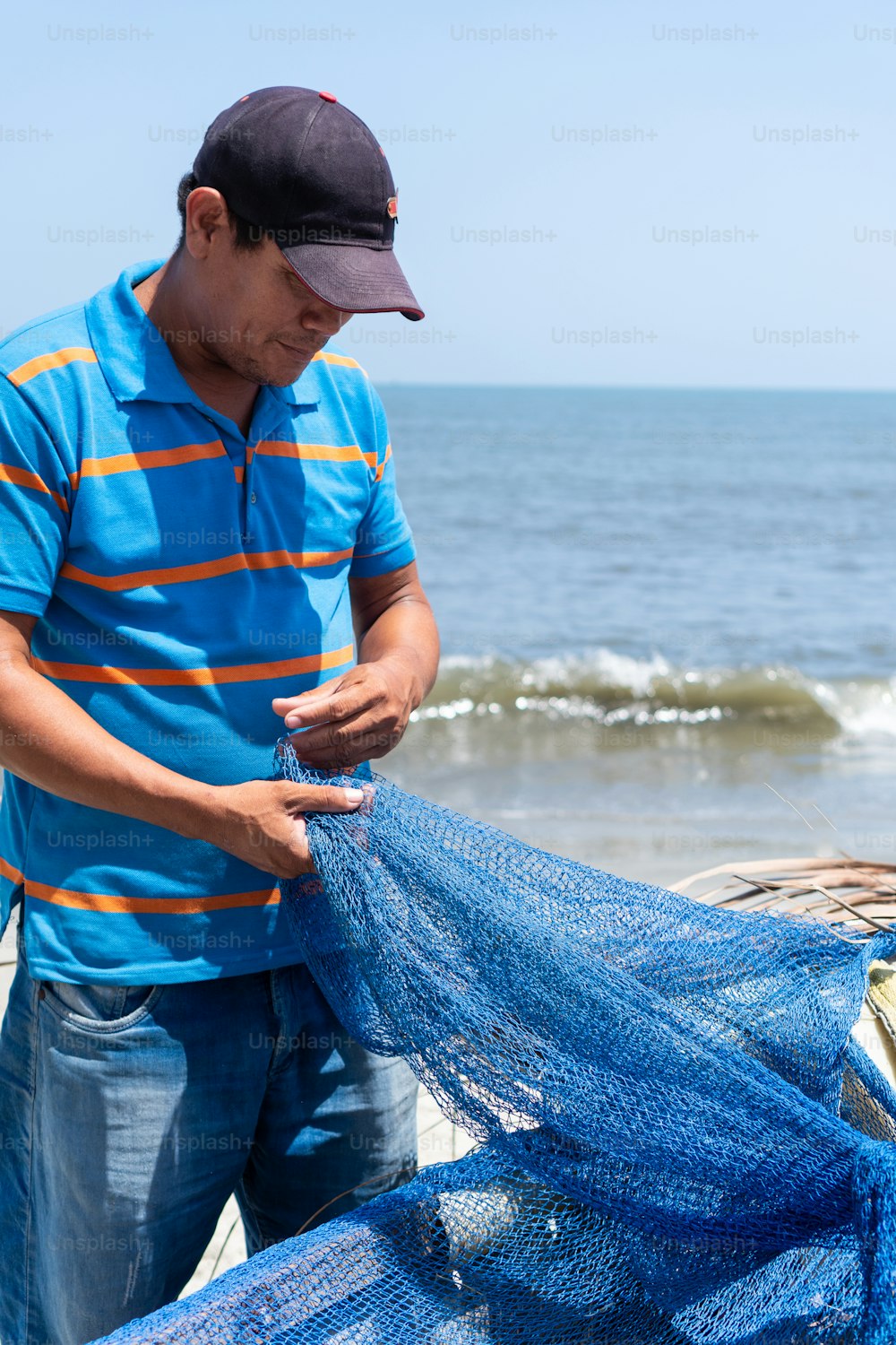 Latin fisherman checking a fishing net on a fishing boat