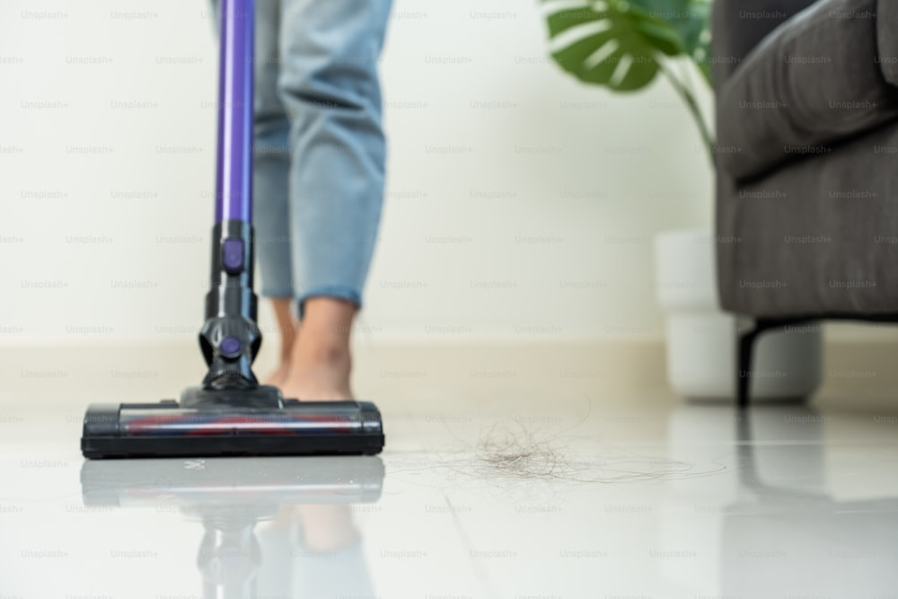 Close-up of housekeeper holding modern washing vacuum cleaner and