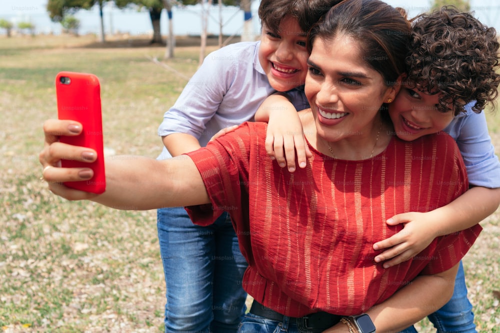 Mother with her children taking a selfie with her cell phone at the park