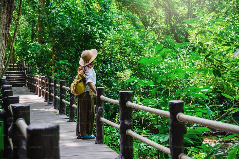La ragazza che cammina nel ponte e si gode il turismo attraverso la foresta di mangrovie. Cascata di Bok Khorani Nature Trail. Krabi, relax, viaggio, zaino, natura, turismo, campagna.