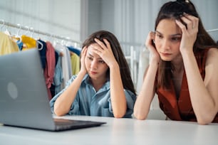 Asian woman friends couple feeling frustrated after check sale order. Young attractive two female working and checking e-commerce shipping for online retail to sell vase goods at home warehouse store.