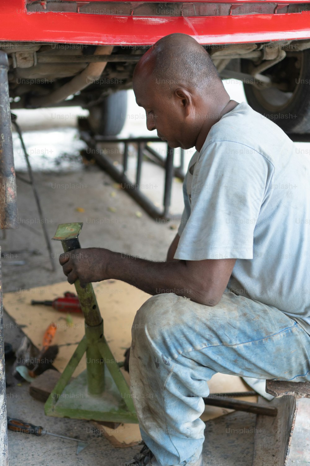 mechanic working under the vehicle in a workshop.