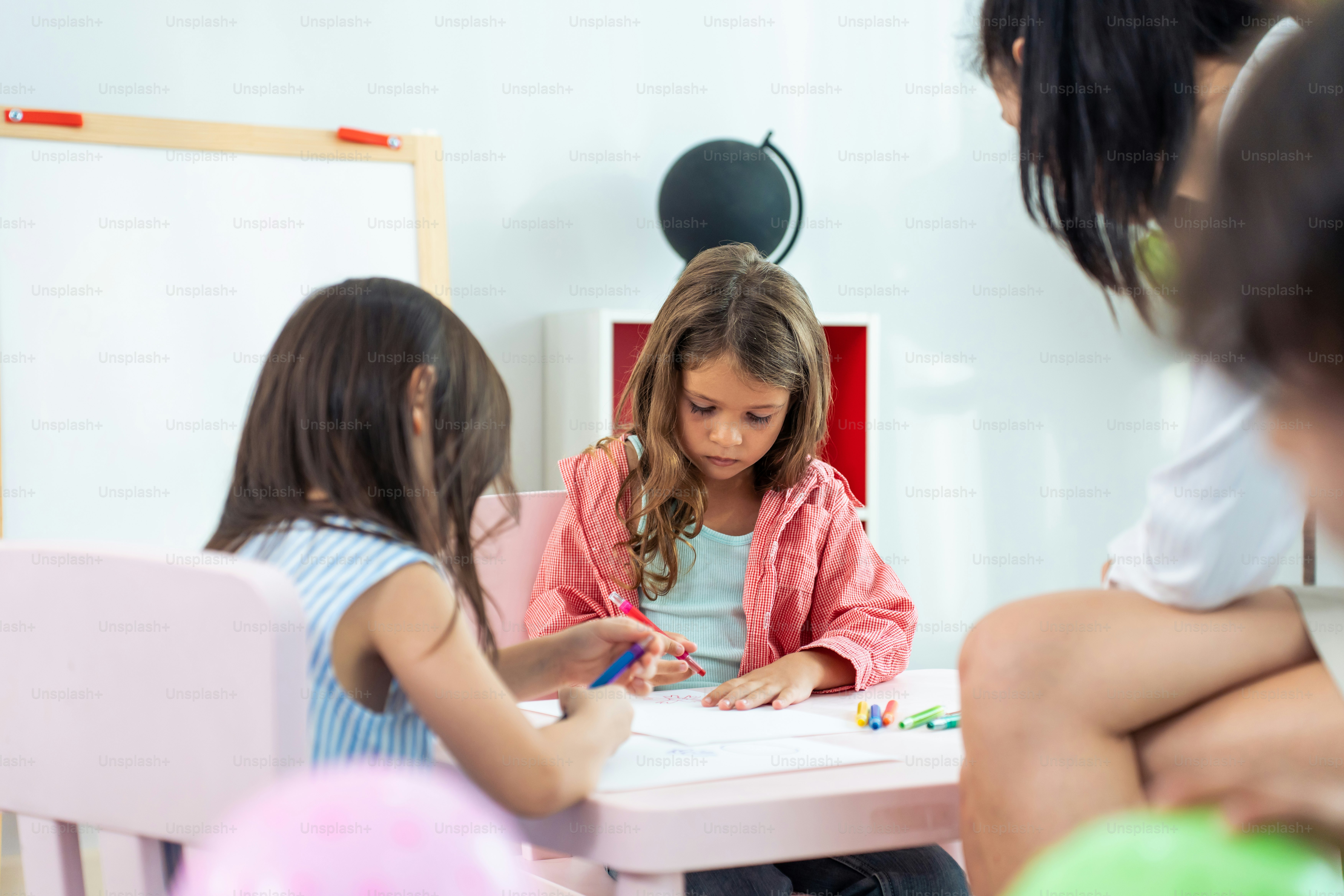 Asian beautiful young woman teacher teaching mixed race kids at school. Attractive women instructor master explain and educate children student with fun activity in classroom at preschool kindergarten