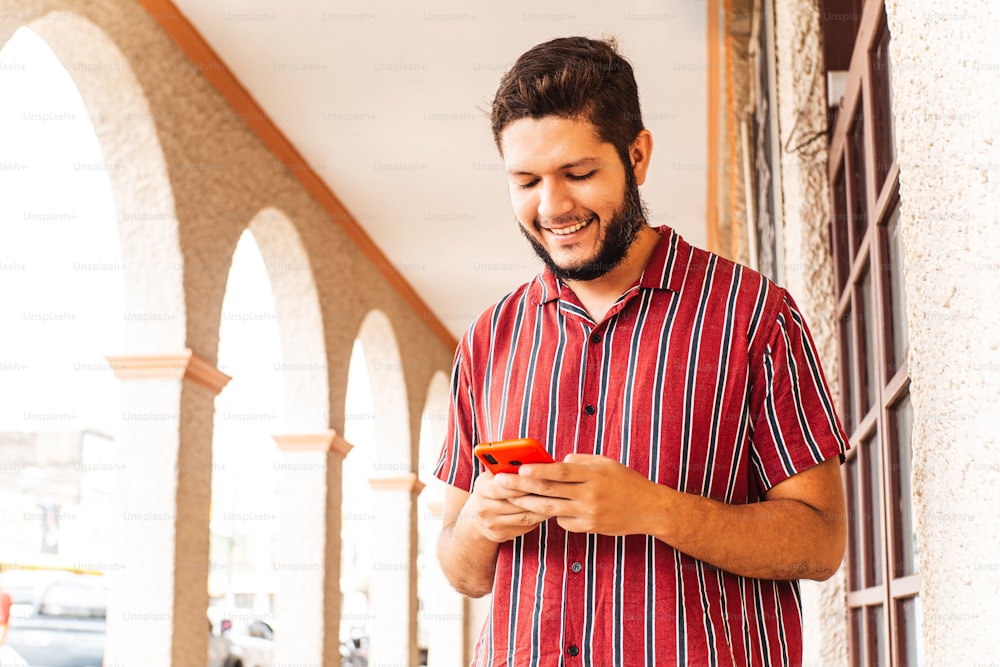 Young latin american man using smartphone at honduras city.