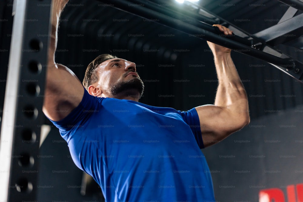 Caucasian sportsman slowly lift up weight machine barbell in stadium. Active fitness trainer or athlete bodybuilder male working out, training exercise to maintain muscle for health care at gym club.